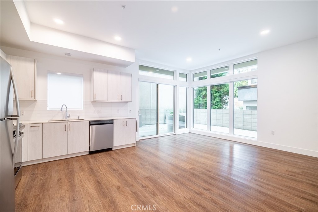 709 East Walnut, Unit 219 Pasadena, CA 91109 - Photo 11 of 38 a large white kitchen with wooden floors and white walls