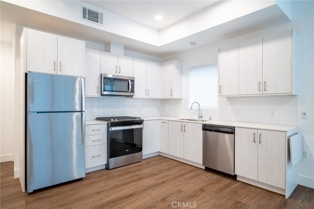 709 East Walnut, Unit 219 Pasadena, CA 91109 - Photo 13 of 38 a kitchen with granite countertop white cabinets and stainless steel appliances
