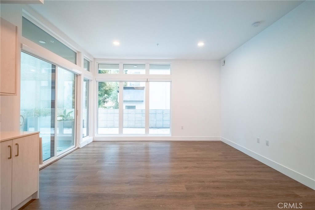 709 East Walnut, Unit 219 Pasadena, CA 91109 - Photo 16 of 38 a view of an empty room with wooden floor and a window