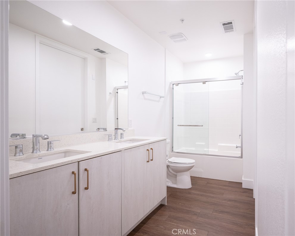 709 East Walnut, Unit 219 Pasadena, CA 91109 - Photo 21 of 38 a bathroom with a toilet a sink and a large mirror