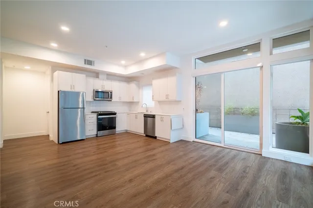 a view of a kitchen with a sink and a refrigerator