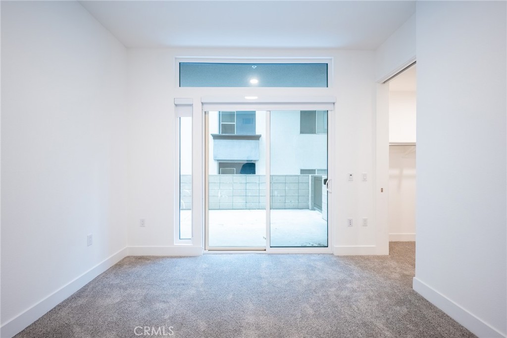 709 East Walnut, Unit 219 Pasadena, CA 91109 - Photo 10 of 38 an empty room with sliding glass door and windows