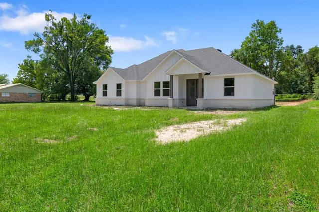 a front view of house with yard and green space