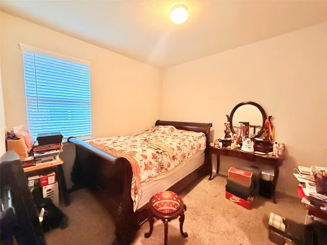 a bedroom with a bed and a flat tv screen on the dresser