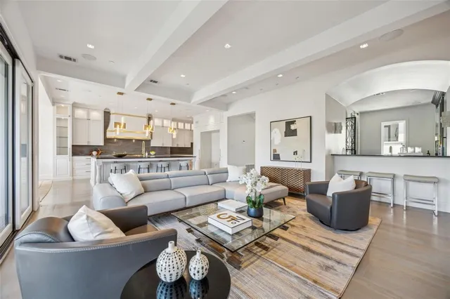 a living room with furniture and a view of kitchen