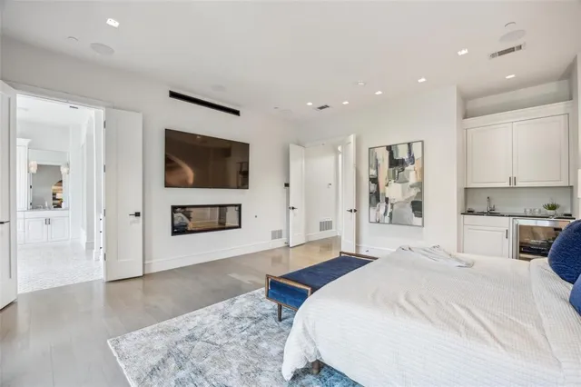 a spacious bedroom with a bed and a flat screen tv