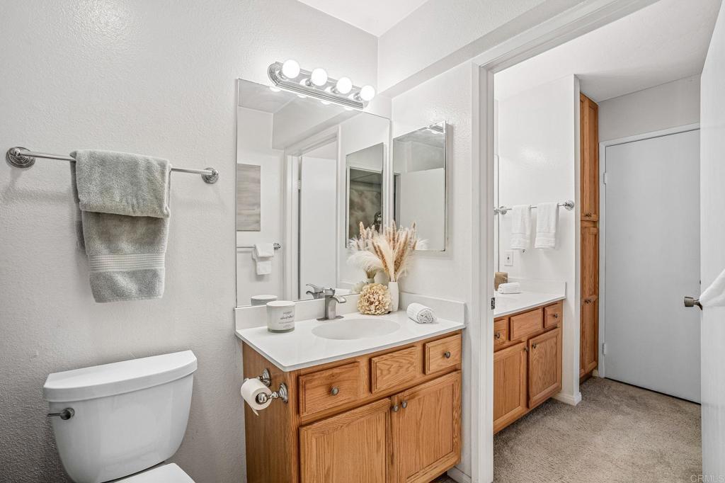 5922 Rancho Mission Road, Unit 78 San Diego, CA 92108 - Photo 13 of 25 a bathroom with a toilet sink and mirror