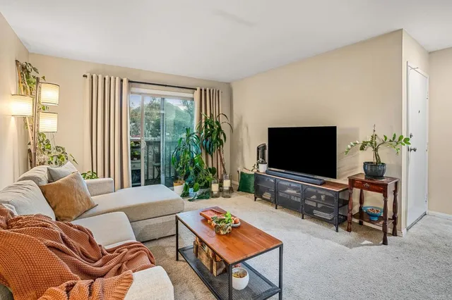 a living room with furniture a flat screen tv and a large window