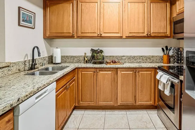 a kitchen with stainless steel appliances granite countertop a sink and a white cabinets