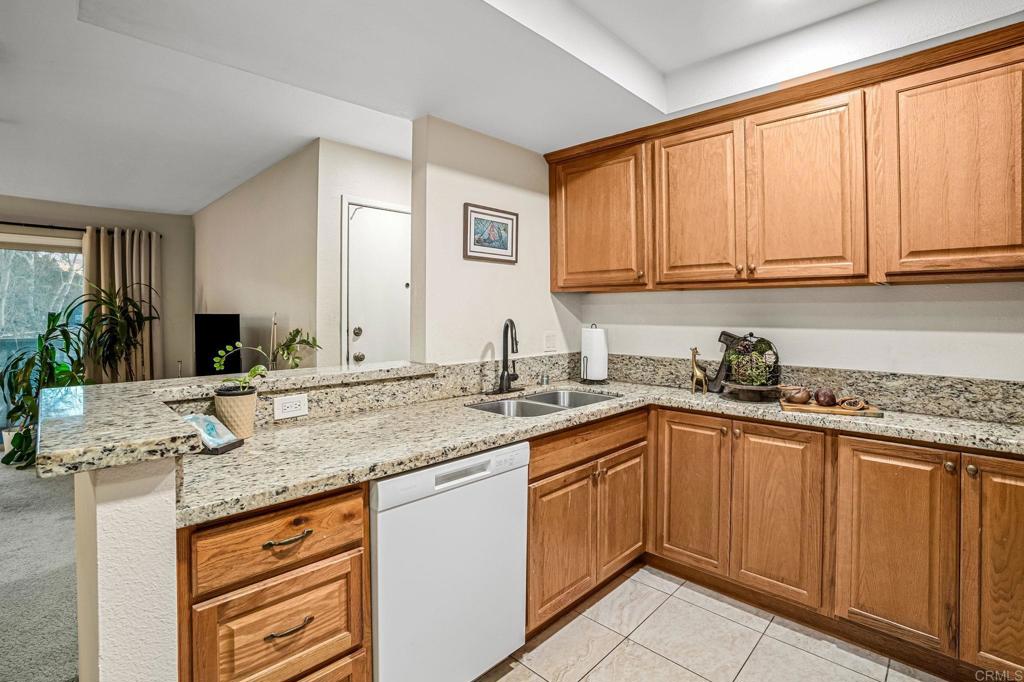 5922 Rancho Mission Road, Unit 78 San Diego, CA 92108 - Photo 9 of 25 a kitchen with stainless steel appliances granite countertop a sink stove and cabinets