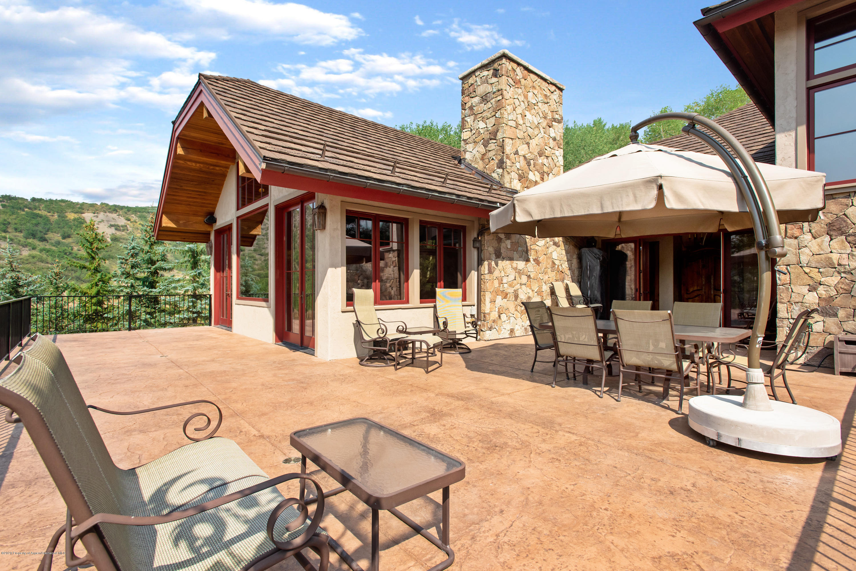 64 Spruce Ridge Lane Snowmass Village, CO 81615 - Photo 33 of 38 a view of a patio with table and chairs under an umbrella