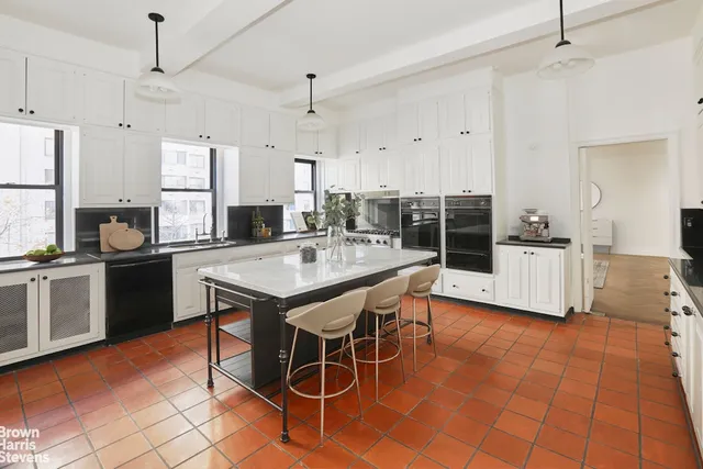 a kitchen with stainless steel appliances kitchen island granite countertop a table chairs and a refrigerator
