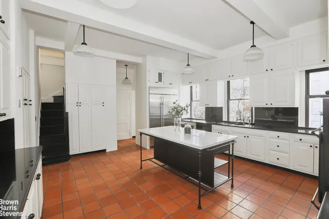 a large white kitchen with a stove a sink dishwasher and a refrigerator with wooden floor