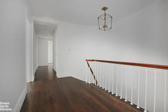 a view of staircase with railing and white walls