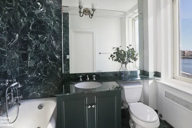 a bathroom with a sink a toilet and a mirror