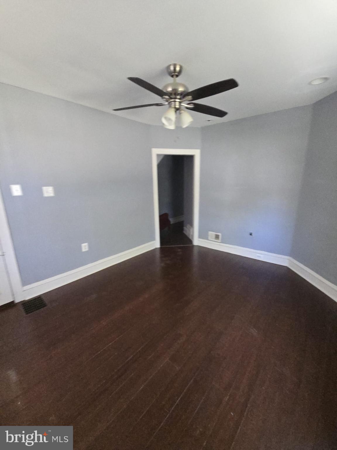 5314 Angora Terrace, Unit 1 Philadelphia, PA 19143 - Photo 4 of 15 an empty room with wooden floor a ceiling fan and a window