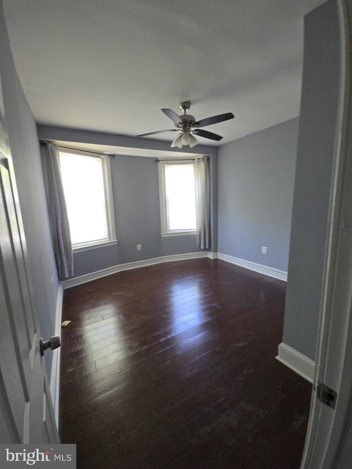 5314 Angora Terrace, Unit 1 Philadelphia, PA 19143 - Photo 6 of 15 an empty room with wooden floor and windows