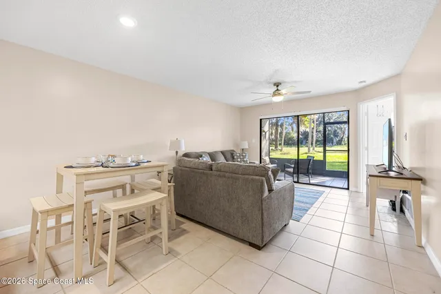 a living room with furniture and a floor to ceiling window