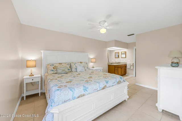 a spacious bedroom with a bed and a lamp