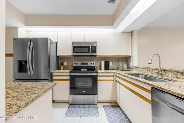 a kitchen with stainless steel appliances granite countertop a sink stove and refrigerator