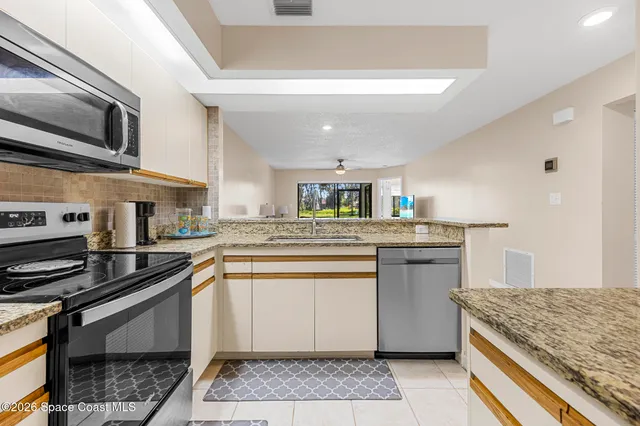 a kitchen with stainless steel appliances granite countertop a sink stove and cabinets