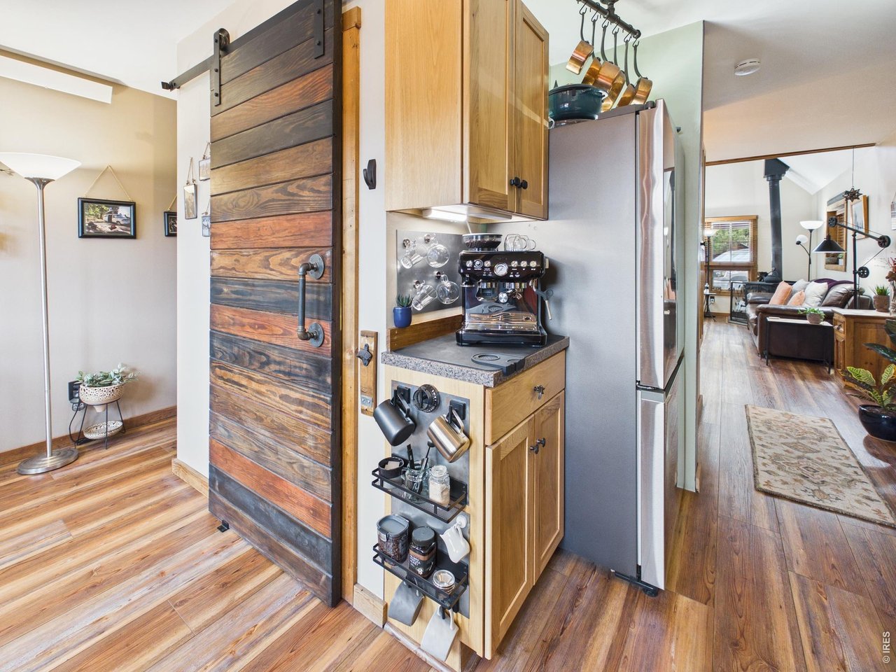 131 West Boulder Street Nederland, CO 80466 - Photo 12 of 46 Coffee center, magnet holder, barn door, rustic flooring, stainless steel refrigerator.