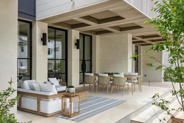 a view of a patio with table and chairs potted plants and floor to ceiling window and potted plants