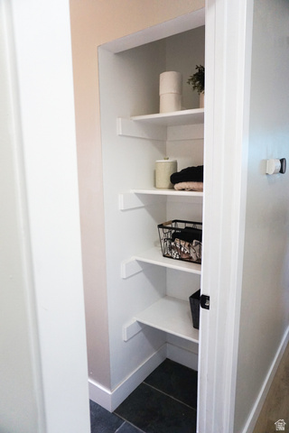 680 Timpie Road Tooele, UT 84074 - Photo 14 of 31 Recessed shelving unit featuring four white shelves, a dark tile floor, and a neutral wall color