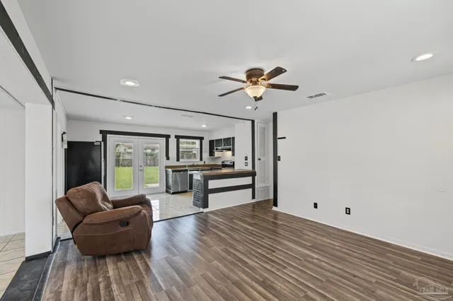 a living room with furniture and a wooden floor