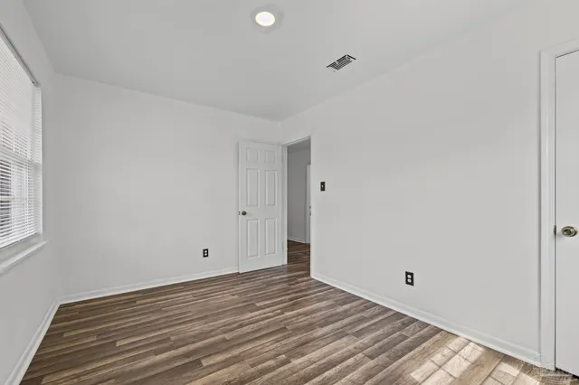 a view of room with window and wooden floor