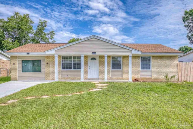 a front view of a house with a garden