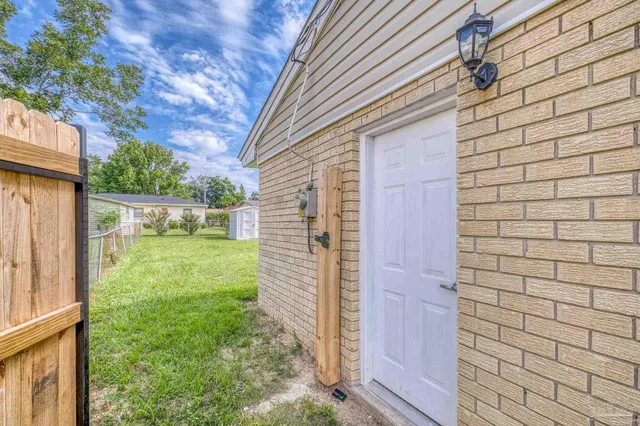 a view of a back yard from a brick wall