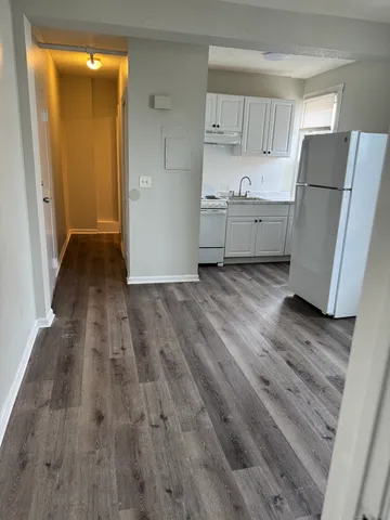 a view of a kitchen with wooden floor and a sink