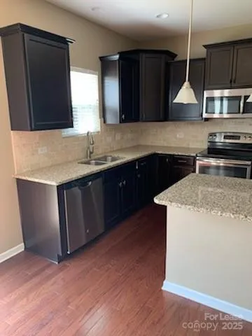 a kitchen with a sink a microwave a stove and cabinets