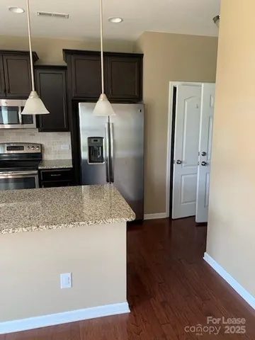 a kitchen with kitchen island a counter top space a sink and a refrigerator