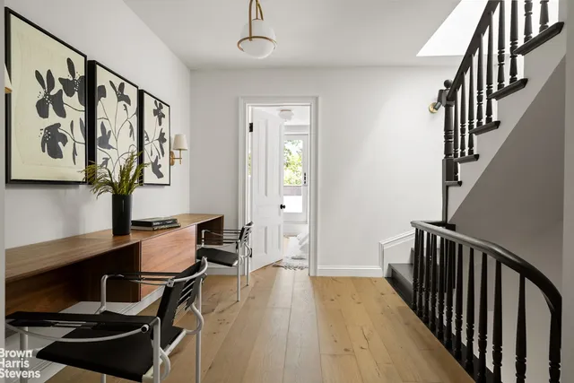 a hallway with wooden floor a dining table and chairs