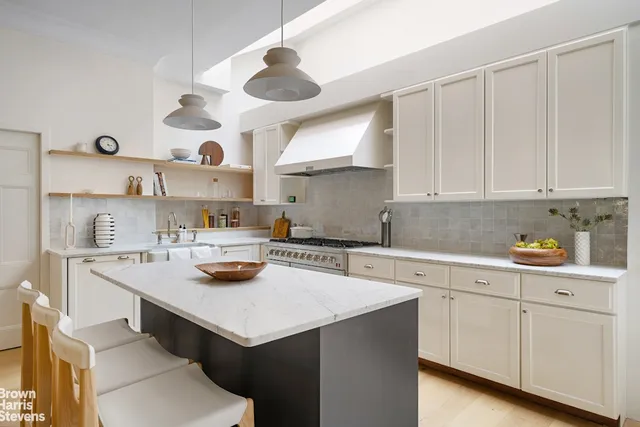 a kitchen with a stove a sink and cabinets