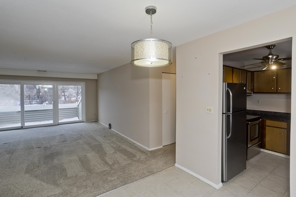 169 Nassau Drive, Unit 169 Springfield, MA 01129 - Photo 11 of 31 a view of empty room with a ceiling fan and window