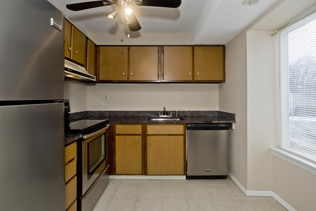 169 Nassau Drive, Unit 169 Springfield, MA 01129 - Photo 12 of 31 a kitchen with stainless steel appliances granite countertop a stove a sink and a refrigerator