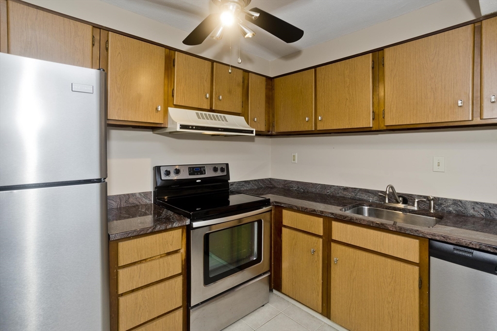 169 Nassau Drive, Unit 169 Springfield, MA 01129 - Photo 13 of 31 a kitchen with stainless steel appliances granite countertop a sink stove and refrigerator