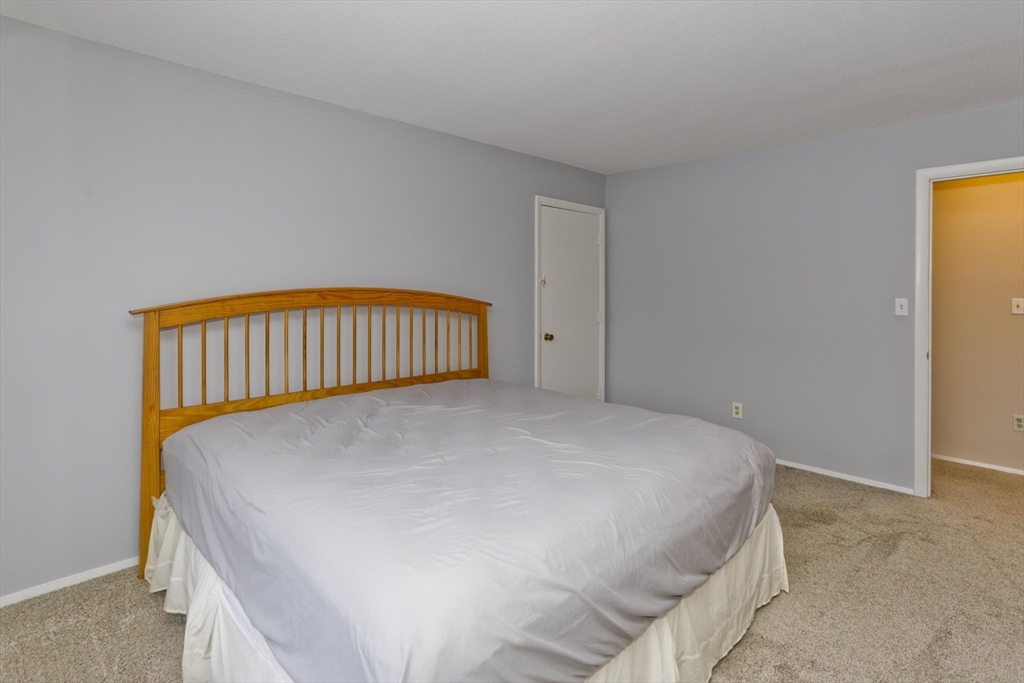 169 Nassau Drive, Unit 169 Springfield, MA 01129 - Photo 21 of 31 a bed sitting in a bedroom next to a window