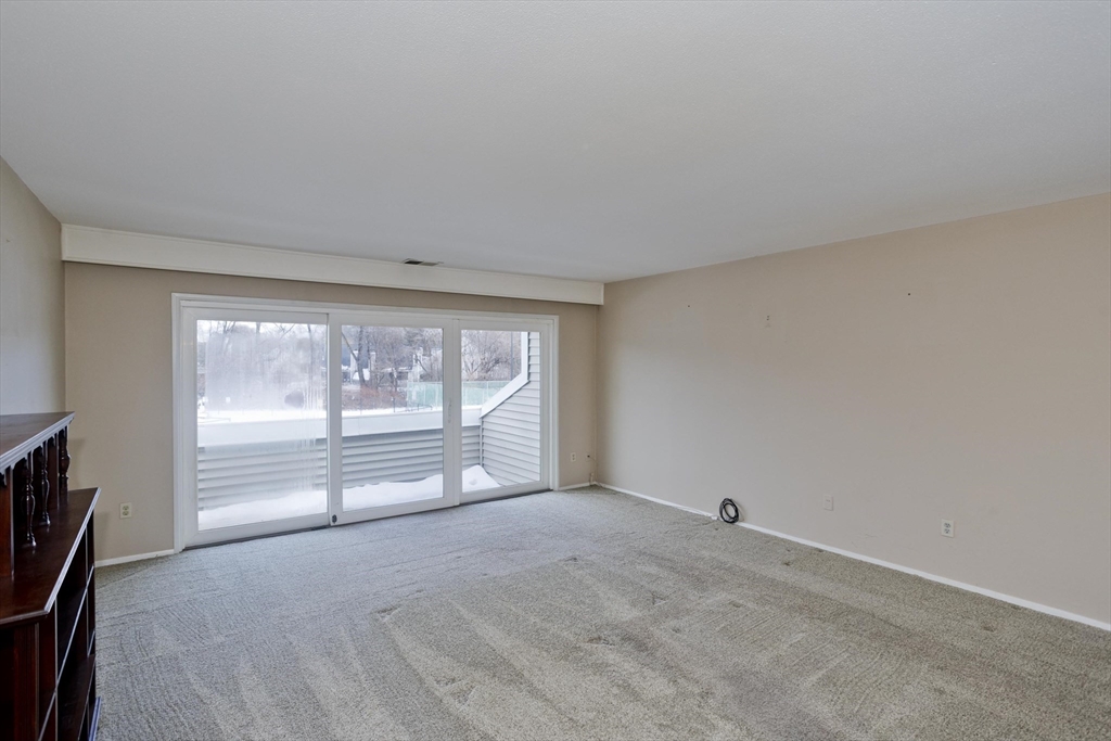 169 Nassau Drive, Unit 169 Springfield, MA 01129 - Photo 3 of 31 a view of an empty room with a fireplace and a window
