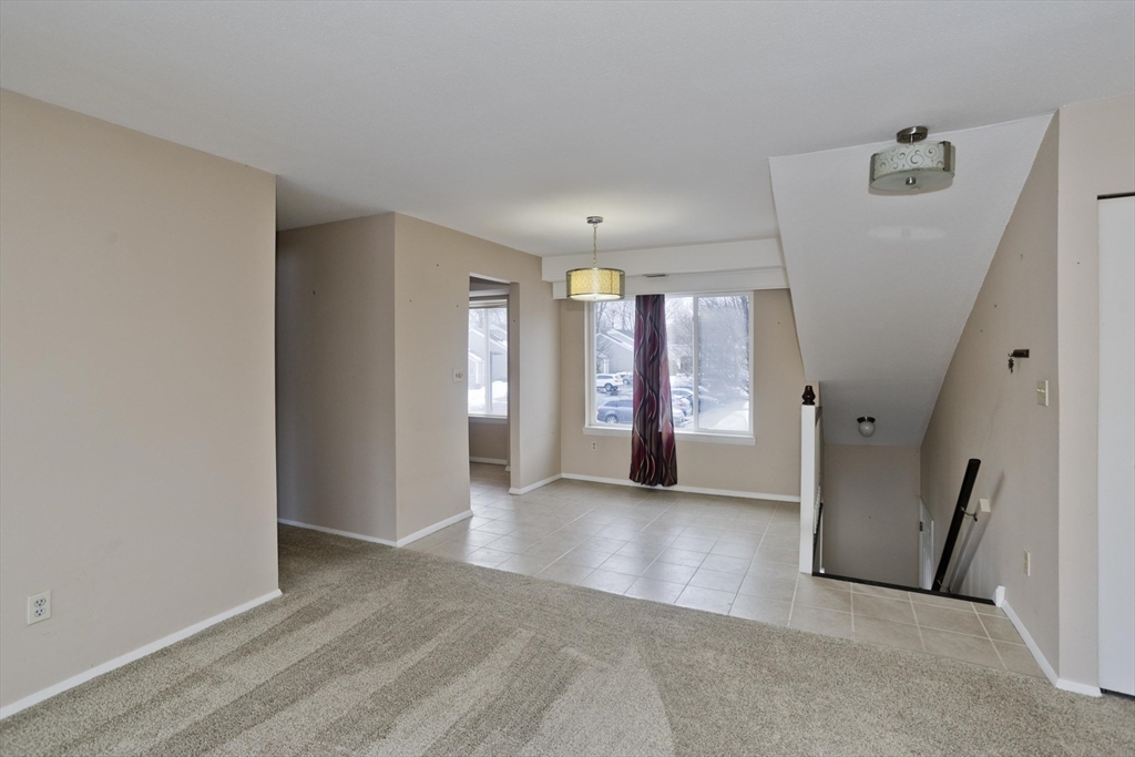 169 Nassau Drive, Unit 169 Springfield, MA 01129 - Photo 7 of 31 wooden floor in an empty room with a window