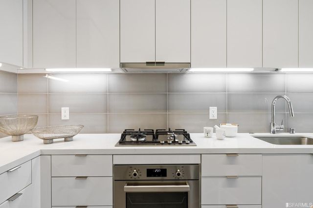a bathroom with a sink a mirror and a potted plant