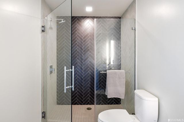 a bathroom with a bathtub shower sink mirror and toilet