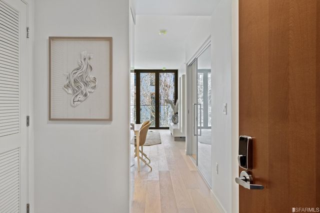 a view of a hallway with bathroom and glass door shower