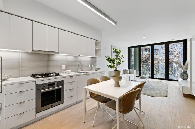 a kitchen with stainless steel appliances granite countertop a sink and a refrigerator
