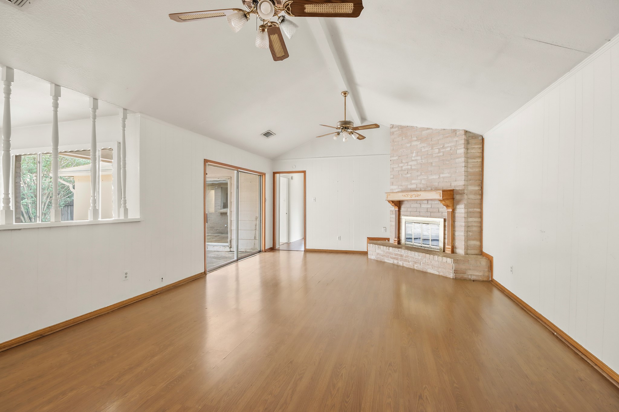 6919 River Mill Drive Spring, TX 77379 - Photo 7 of 26 Spacious living room with vaulted ceilings, brick fireplace, and abundant natural light.