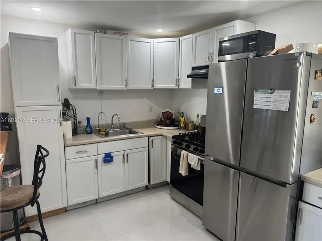 a kitchen with stainless steel appliances a refrigerator sink and cabinets