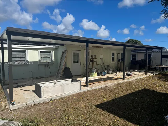 a view of a house with backyard porch and sitting area